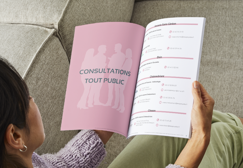 Une femme assise avec dans ses mais un magazine